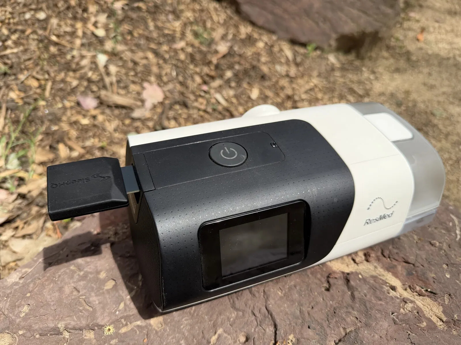 A MUX inserted in the SD card slot on the side of a ResMed AirSense 11